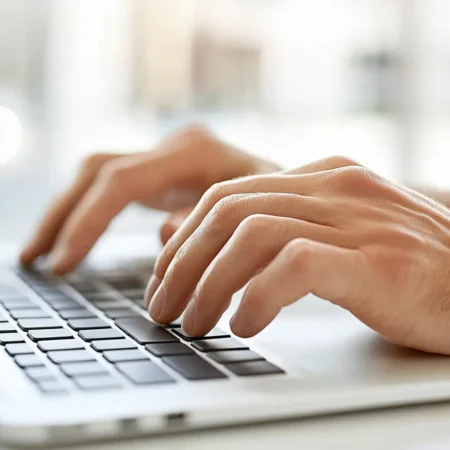 Mains tapant sur un clavier d'ordinateur